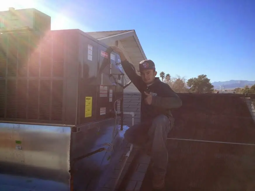 HVAC technician performing AC Tune-Up on a rooftop unit in Closter